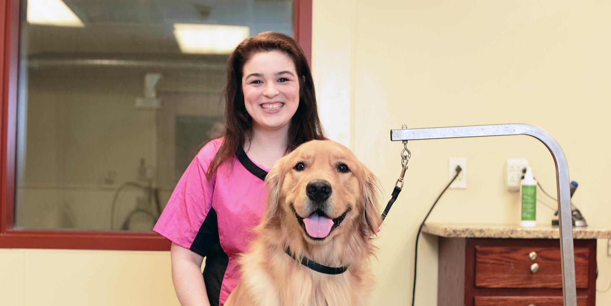 dog-grooming-header Groomer posing with a dog